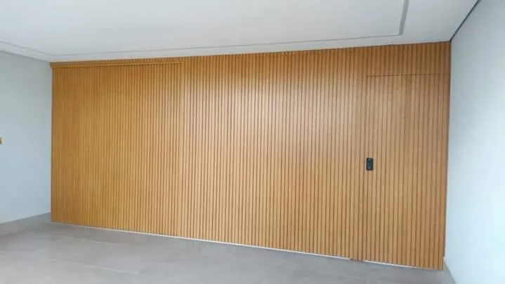 Painel ripado amadeirado com porta camuflada